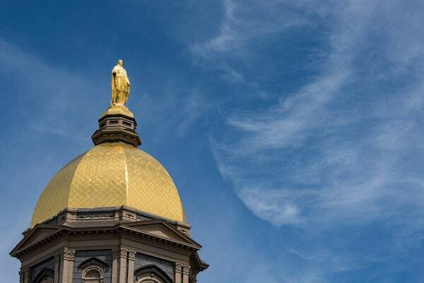 The golden dome with the statue of Mary atop, a blue sky with whispy clouds in the background